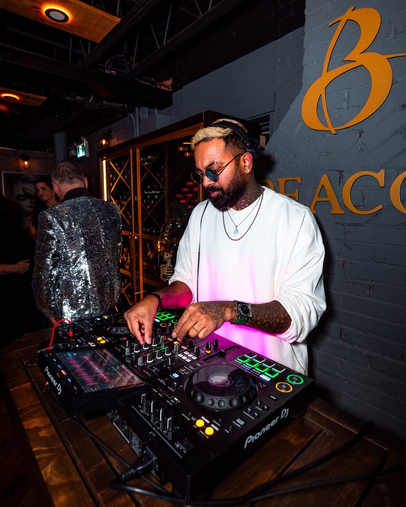 The resident DJ at the decks beneath the gold Beacon lettering